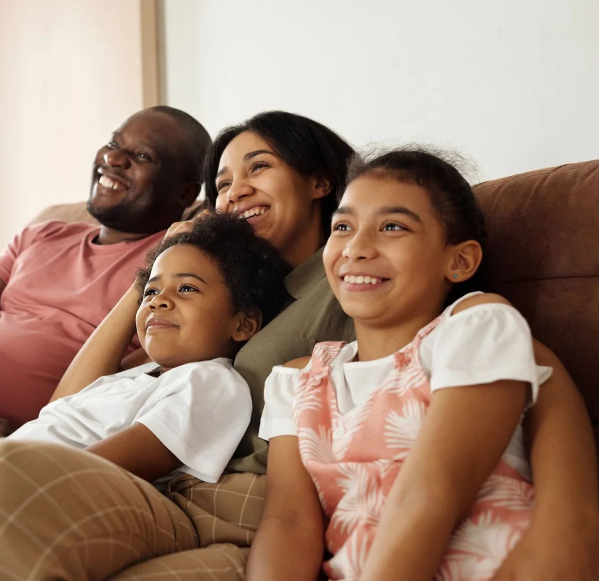 Smiling family relaxing together on a living room sofa
